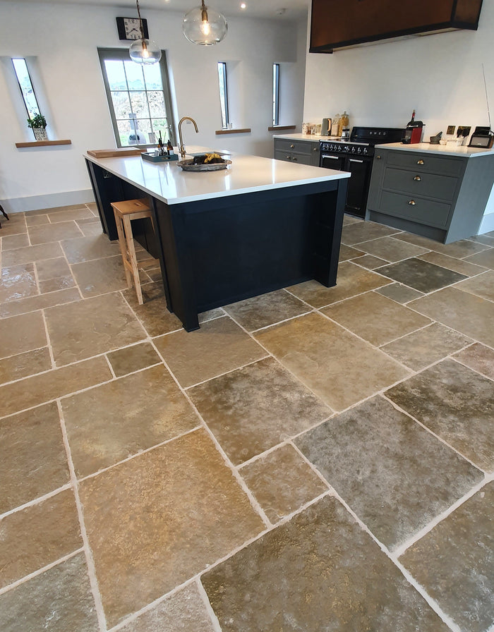 Natural Stone Online Minster Antiqued Limestone tiles in the opus pattern with black kitchen island in converted barn