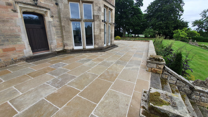 Natural Stone Online Minster Antiqued Limestone exterior paving tiles on the grounds of a stately home near the entrance