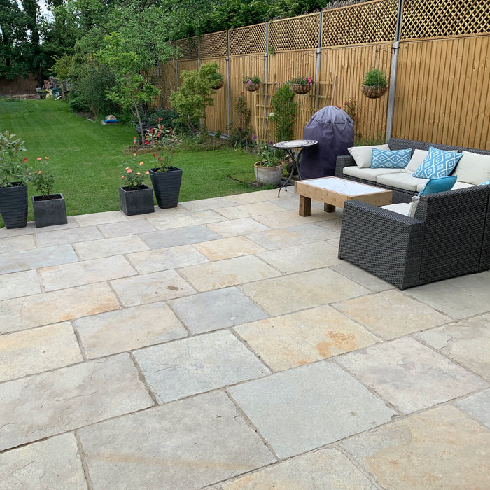 Minster Natural Finish Limestone external paving tiles in garden with rattan furniture and fence with top panel