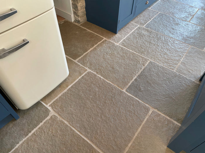 Natural Stone Online Minster Antiqued Limestone tile with navy blue kitchen cabinets and cream Smeg fridge
